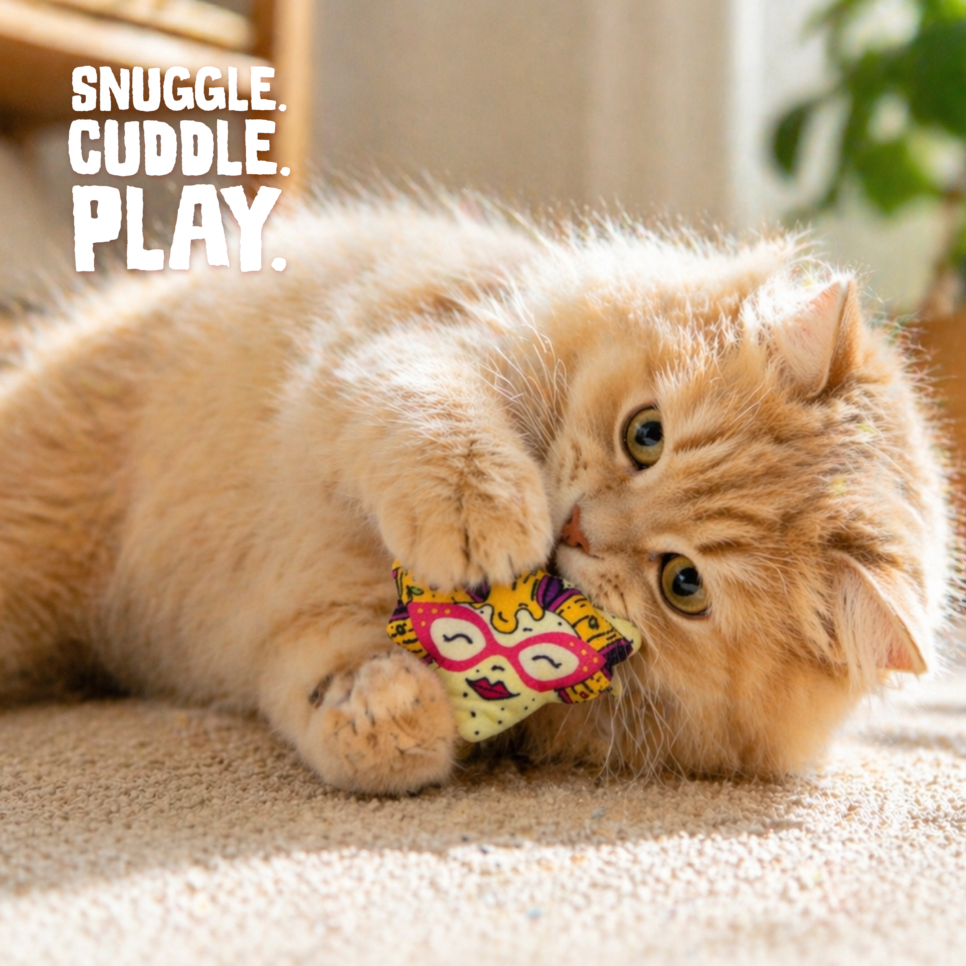 The Snugarooz Nacho Kitty with Catnip is a durable cat toy shaped like a pizza slice, with a cartoon face featuring pink glasses, closed eyes, red lips, and yellow cheese hair with purple and brown toppings.