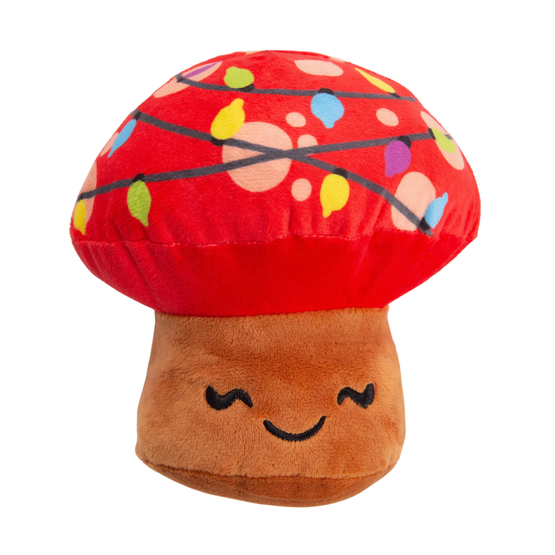 The Snugarooz Merry Mushroom is a plush dog toy shaped like a smiling mushroom with a red cap, colorful string lights, and brown stem—perfect for festive holiday fun.