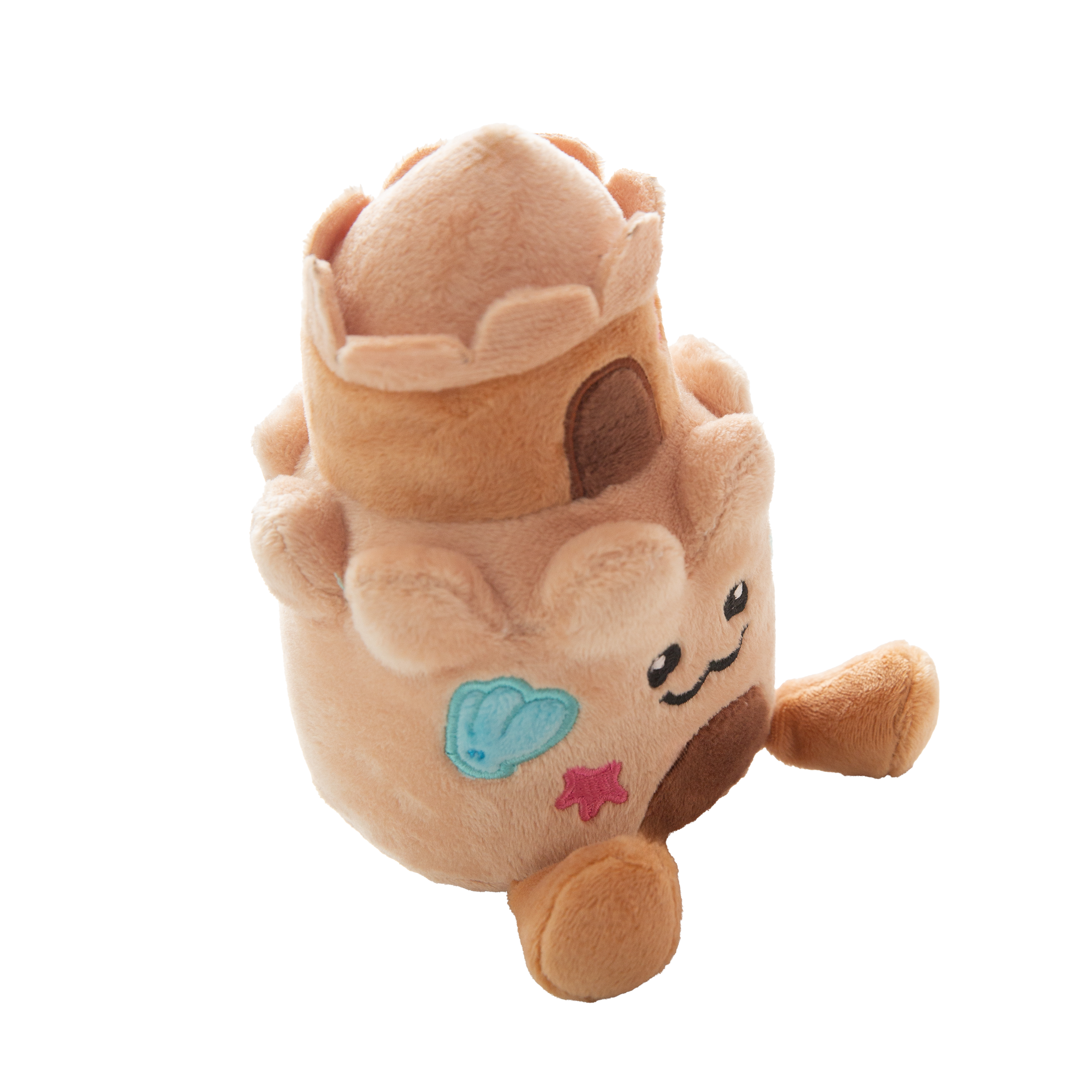 The Snugarooz Snugz Castle is a plush dog toy shaped like a sandcastle, featuring a smiling face, blue shell designs, pink starfish accents, and a brown doorway on a white background.