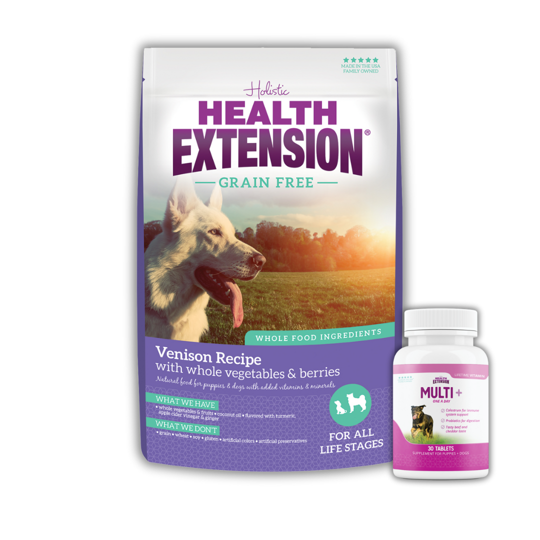 A package of Health Extension Grain-Free Venison Recipe dog food and a bottle of Multi+ dog vitamins, with an image of a white dog on the bag.