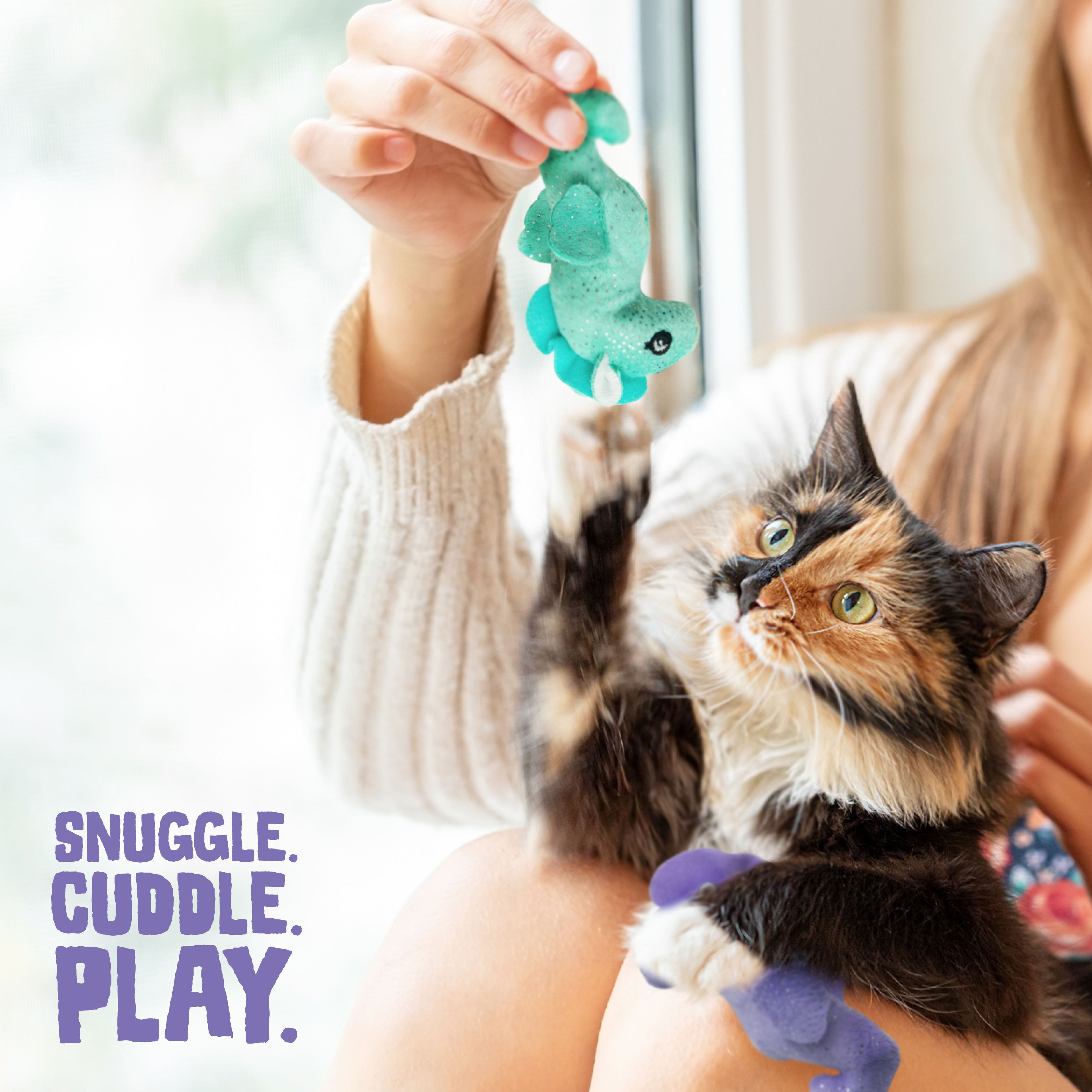The Snugarooz Kitty Seahorse 2pk with Catnip features two plush seahorse cat toys—one purple with lavender accents and one turquoise with teal and white accents—both adorned with silver speckles, shown on a white background.